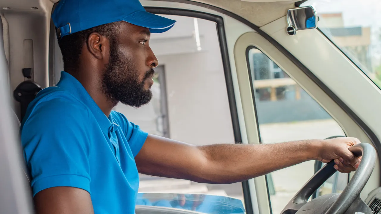African American delivery man driving van