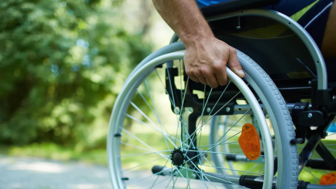 Man pushing wheelchair with hands